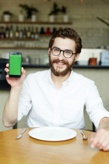 Happy cafe visitor showing online menu in smartphone