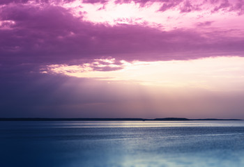 Fototapeta na wymiar Sunset rays over the ocean landscape background