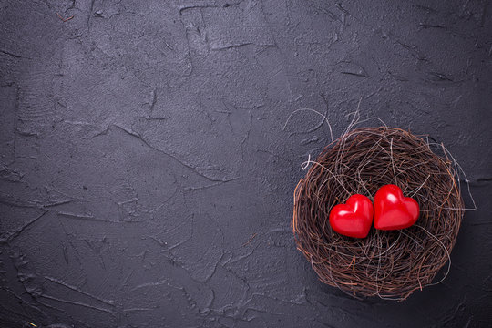 Hearts  in nest on black slate background.