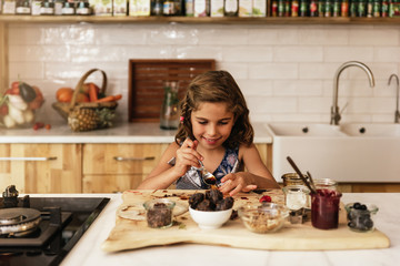 Portrait of little girl preparing baking cookies.