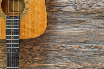Obraz premium Acoustic guitar against a wooden background with copy space