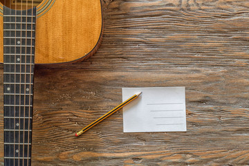 Acoustic guitar against a wooden background with copy space