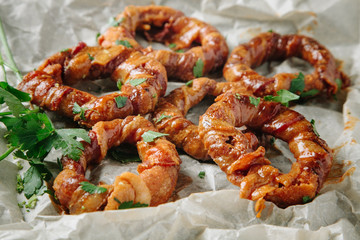 Onion rings seasoned with fresh parsley on parchment paper