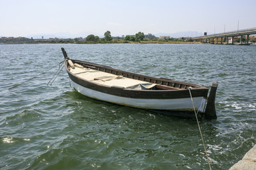 Naklejka na ściany i meble Little wooden boat in a river side