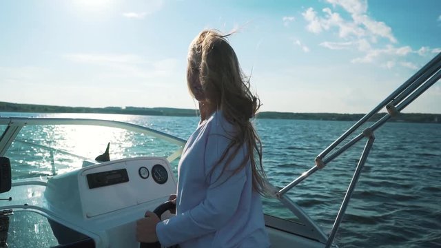 Summer vacation - young girl driving a motor boat