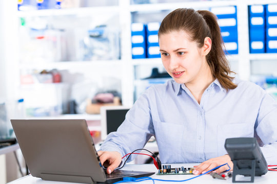 Young woman in electronics repair service center