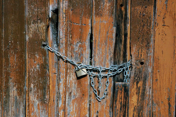 candado con cadena en una puerta vieja