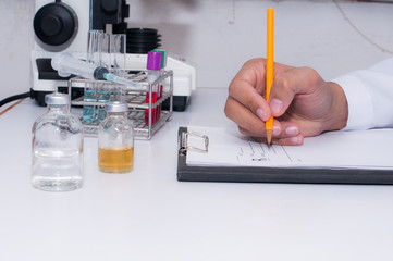 Scientist writing result the test in laboratory room. Scientific research
