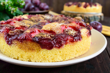 Plum pie on a dark wooden background. American traditional pastries.