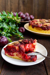 A piece of plum pie  on a dark wooden background. American traditional pastries.