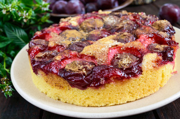Plum pie on a dark wooden background. American traditional pastries.
