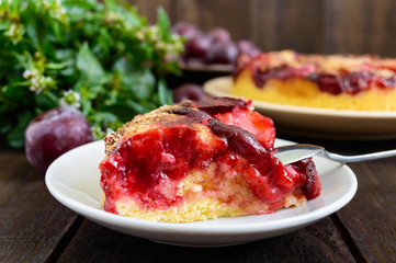 A piece of plum pie  on a dark wooden background. American traditional pastries.