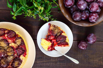 A piece of plum pie  on a dark wooden background. American traditional pastries.
