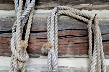 Fototapeta na wymiar Old rope suspended on a wooden brown beam