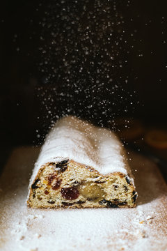Food: sprinkling icing sugar on Christmas stollen cake