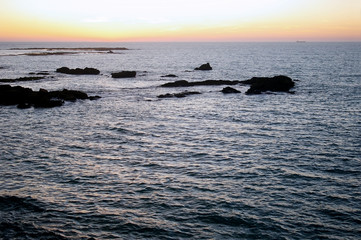 atardecer en la playa con agua de mar y cielo nublado en la ciudad de Cádiz, Andalucía. España