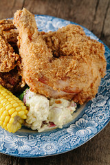 Fried crispy chicken with corn on the cob and potato salad 