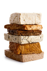 Stack of mixed tofu blocks isolated on white.