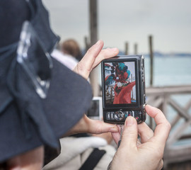 Woman taking picture of Carnival mask in Venice.
