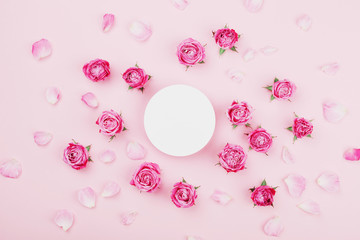 White round blank, pink rose flowers and petals for spa or wedding mockup on pastel background top view. Beautiful floral pattern. Flat lay style.