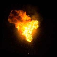 Realistic fiery explosion with sparks over a black background