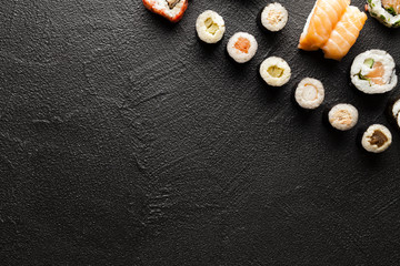 Fototapeta na wymiar Japanese sushi rolls on black table