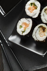 Sushi rolls on black plate