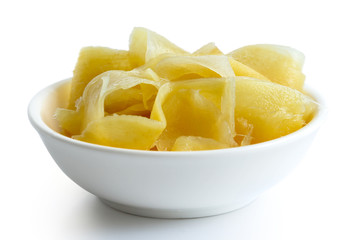 Pickled ginger slices in white ceramic bowl isolated on white.