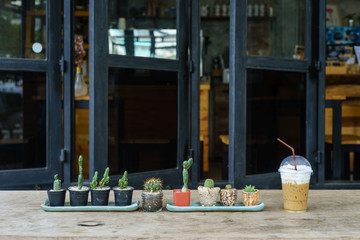 ice cappuccino on wooden table with cactus at cafe