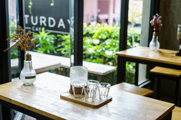 brew coffee in jar with glasses on wood table at cafe