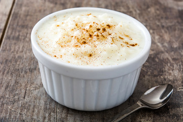 Arroz con leche. Rice pudding with cinnamon on wooden background
