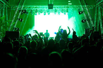 Fototapeta na wymiar Silhouettes of concert crowd in front of bright stage lights