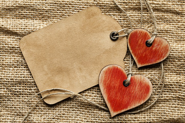 Wooden hearts and paper sheet on fabric background