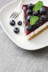 Piece of blueberry cheesecake on gray stone
