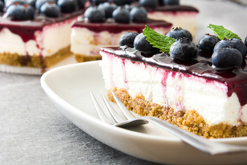 Piece of blueberry cheesecake on gray stone
