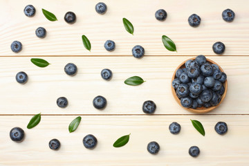 Naklejka na ściany i meble blueberries in wooden bowl on light wooden table background. top view