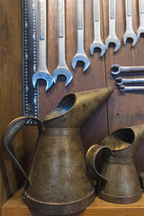 oil can metal big and small on the table with spanner on wood background