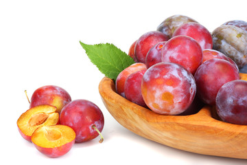 Fototapeta na wymiar raw fresh plum in wooden bowl isolated on white background