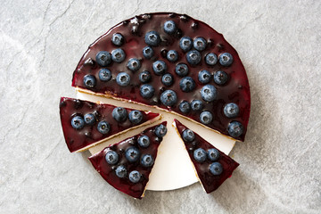 Piece of blueberry cheesecake on gray stone
