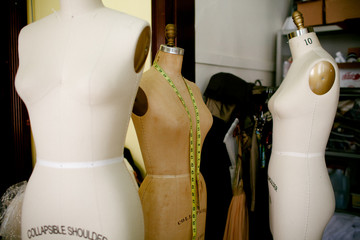 3 dress forms with measuring tape.