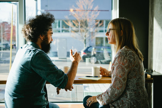 Man and Woman having a discussion over coffee