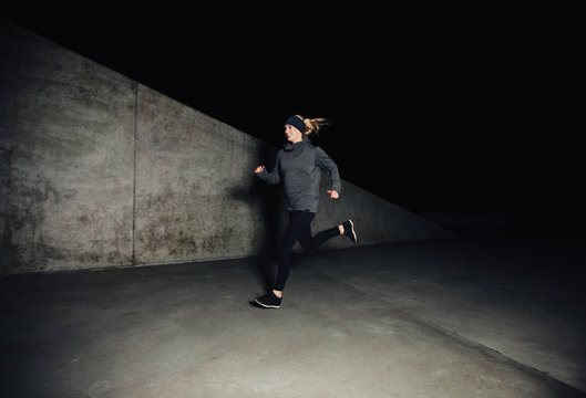 Fit young caucasian woman running on street