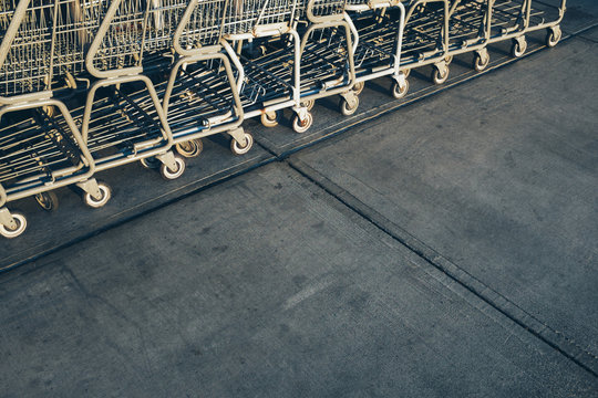 Metal grocery carts lined up on sidewalk outside supermarket