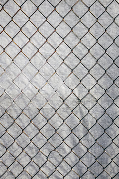Chainlink fence in front of silver tarp