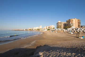 landscape sandy Heliopolis Beach, in Benicassim, Castellon, Valencia, Spain, Europe. Buildings, blue clear sky and Mediterranean Sea
