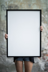 Girl holds a frame for a poster presentation