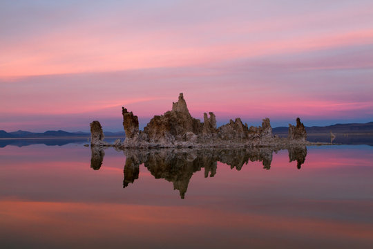 Pastel Sunset over Calm Lake with Natural Formations
