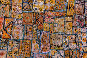 Colourful decorative pattern of squares on a traditional Indian piece of fabric. Warm colours. India texture