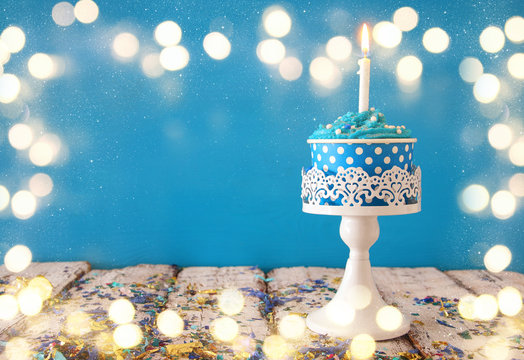 Birthday concept with cupcake and candle on wooden table