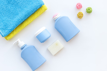 Bath accessories. Towels, soap, shampoo, lotion, cream on white background top view copyspace